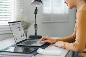 Persona revisando su score financiero en una computadora, analizando su historial de pagos y deudas.